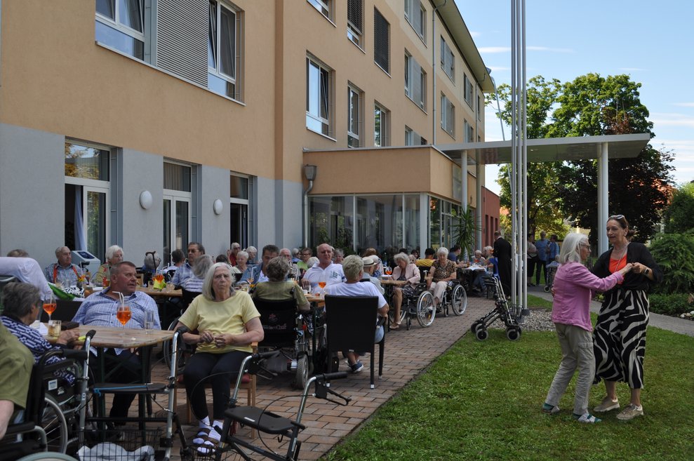 Überblick über den italienischen Nachmittag und zwei Damen tanzen im Garten