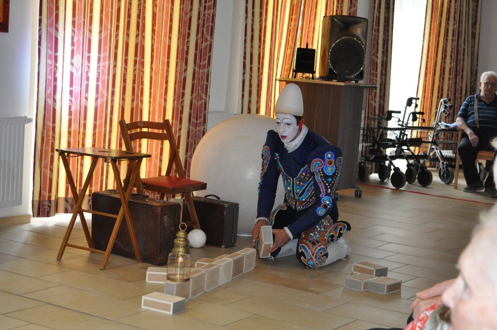 ein Clown sitzt am Boden und baut etwas