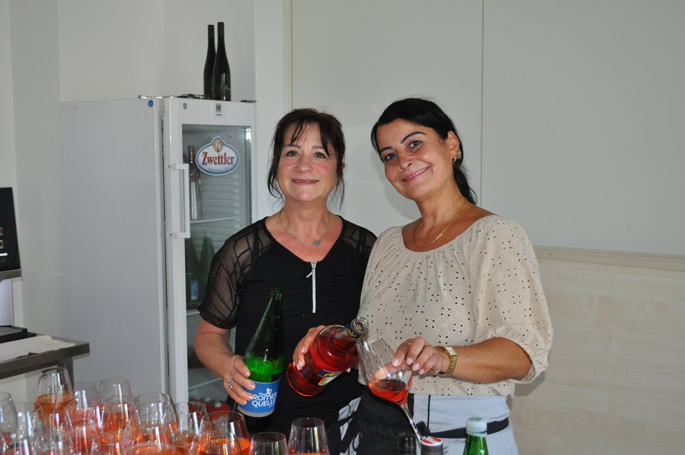 Zwei Kaffeehausmitarbeiterinnen beim Aperol einschenken
