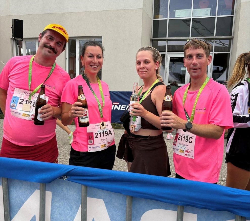 Vier Personen mit einer Flasche Bier nach dem Vision Run