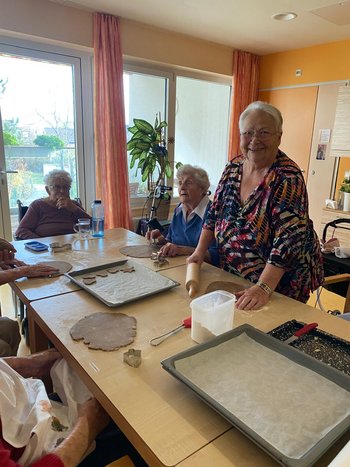 eine ältere Dame beim Kekse ausstechen