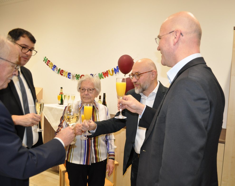 Mehrere Personen stoßen mit Sektgläsern an