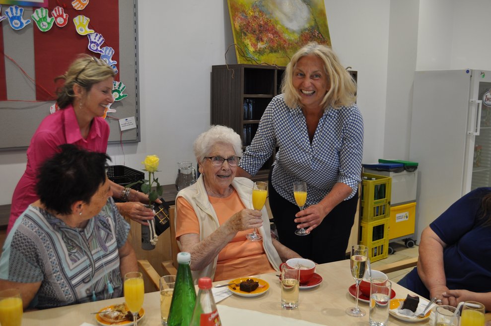 eine Frau gratuliert einer älteren Dame zum Geburtstag