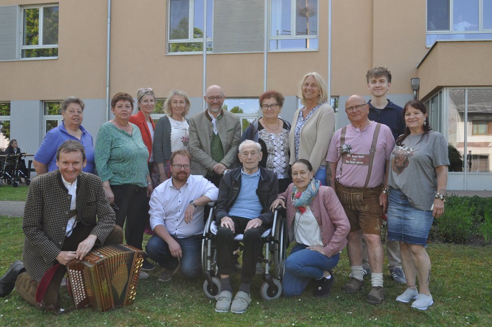 ein Gruppenfoto von Ehrenamtlichen, Bürgermeister, Direktoren, Musiker und einem Bewohner