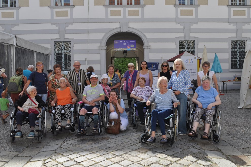einige ältere Menschen mit Rollstühlen und Rollatoren vor dem Stift Herzogenburg