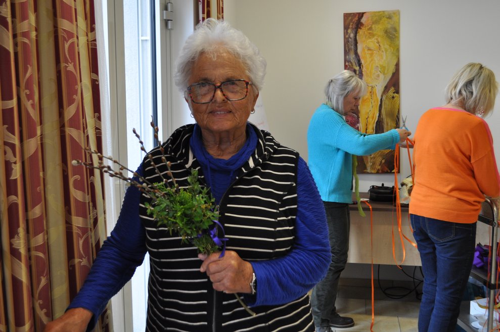 eine ältere Dame mit ihrem Palmbuschen in der Hand